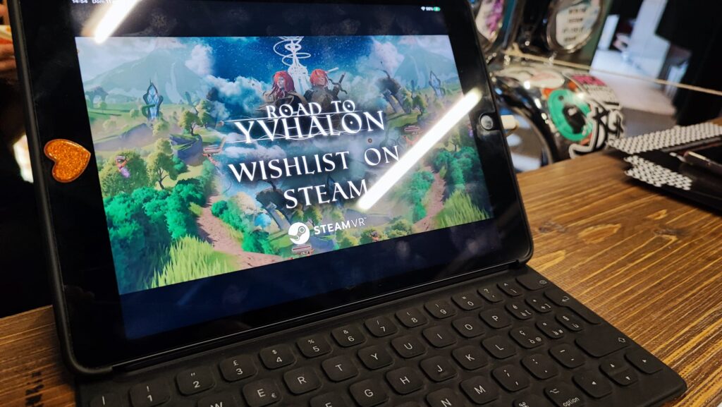 Locandina del gioco VR Road to Yvhalon mostrata sullo schermo di un tablet con tastiera.